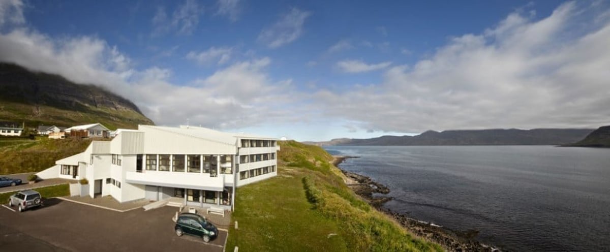 The white Cliff hotel building beside the fjord